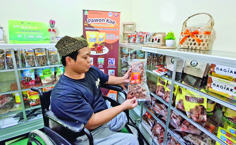 Feri Anwar pemuda disabilias asal Kecamatan Sempu memperlihatkan produk olahan hasil laut bermerek Pawon Koe yang kini sudah menembus pasar internasional.