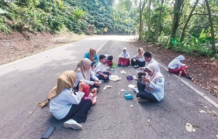 PIKNIK: Siswa dan guru SLB Bhakti Pertiwi, Tegalpakis, Desa Kalibaru Wetan, Kecamatan Kalibaru, Banyuwangi, makan bersama di Jalur Gumitir, setelah belajar bersama di luar sekolah, Senin (1/9).