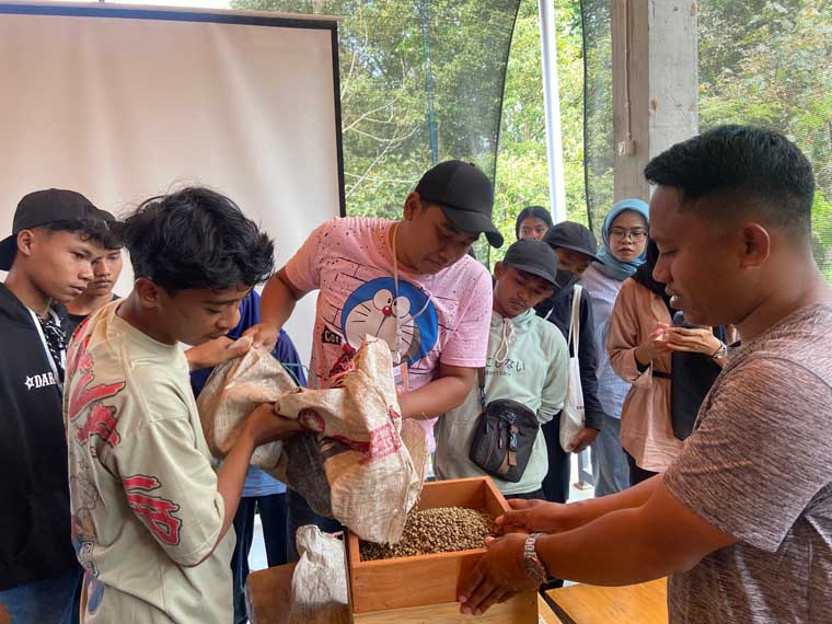Rizal Dhofir (kanan), alumni Jagoan Tani 2023 sedang menyortir kopi saat pembelajaran pengolahan kopi pada anak-anak putus sekolah di Zafir Coffee Kalibaru.