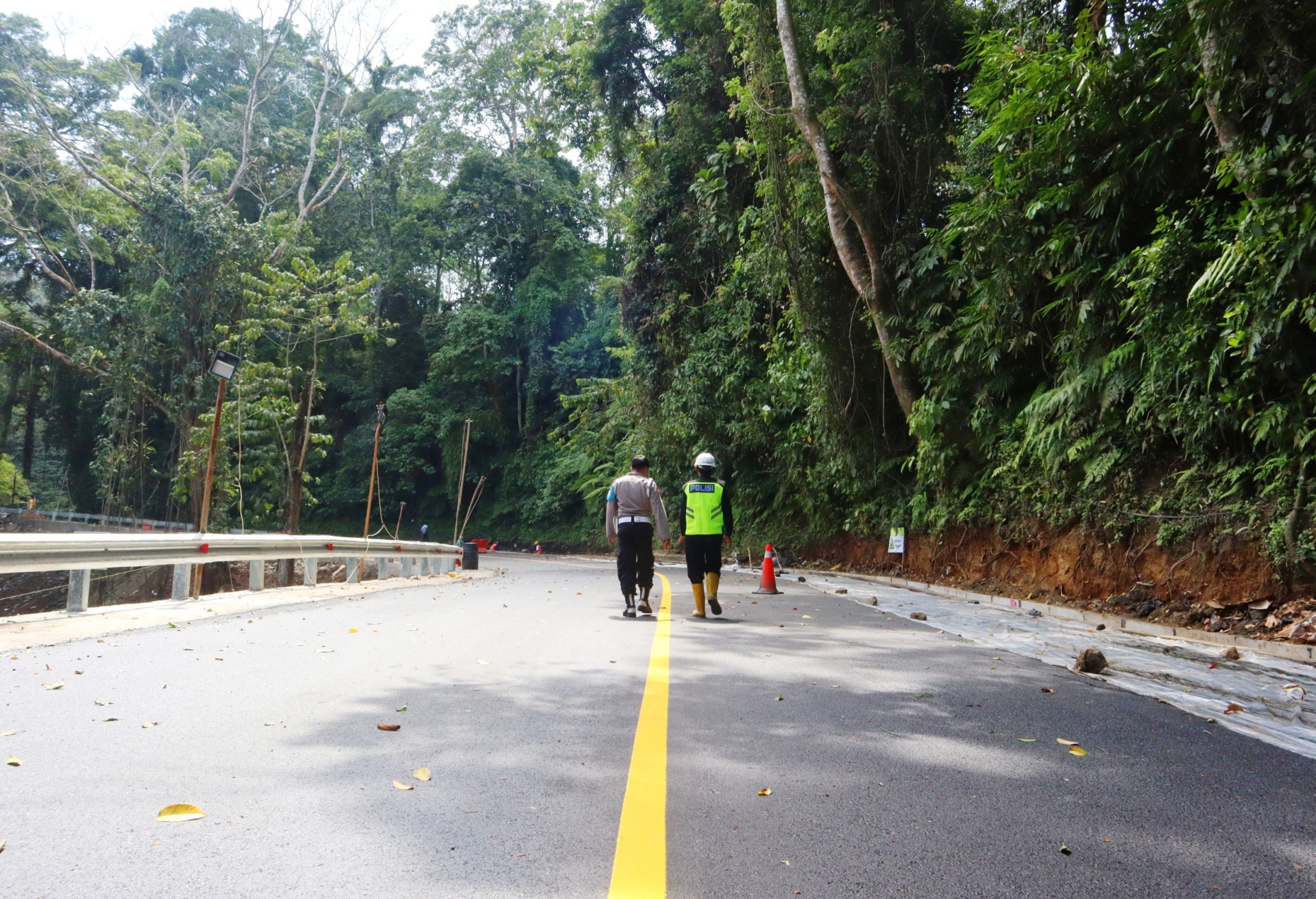 SUDAH MULUS: Petugas mengecek markah jalan di Gunung Gumitir. Jalan penghubung Banyuwangi-Jember ini siap dibuka 4 September pukul 00.00 WIB.