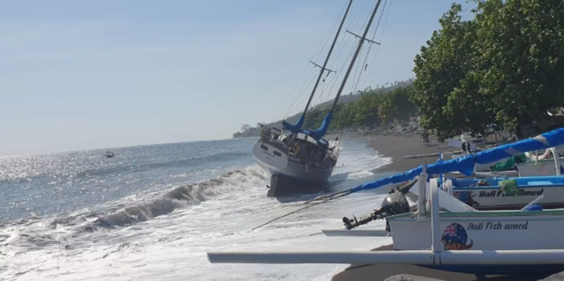 TERDAMPAR: Kapal layar terdampar di Pantai Amed Karangasem Bali usai dihantam cuaca buruk