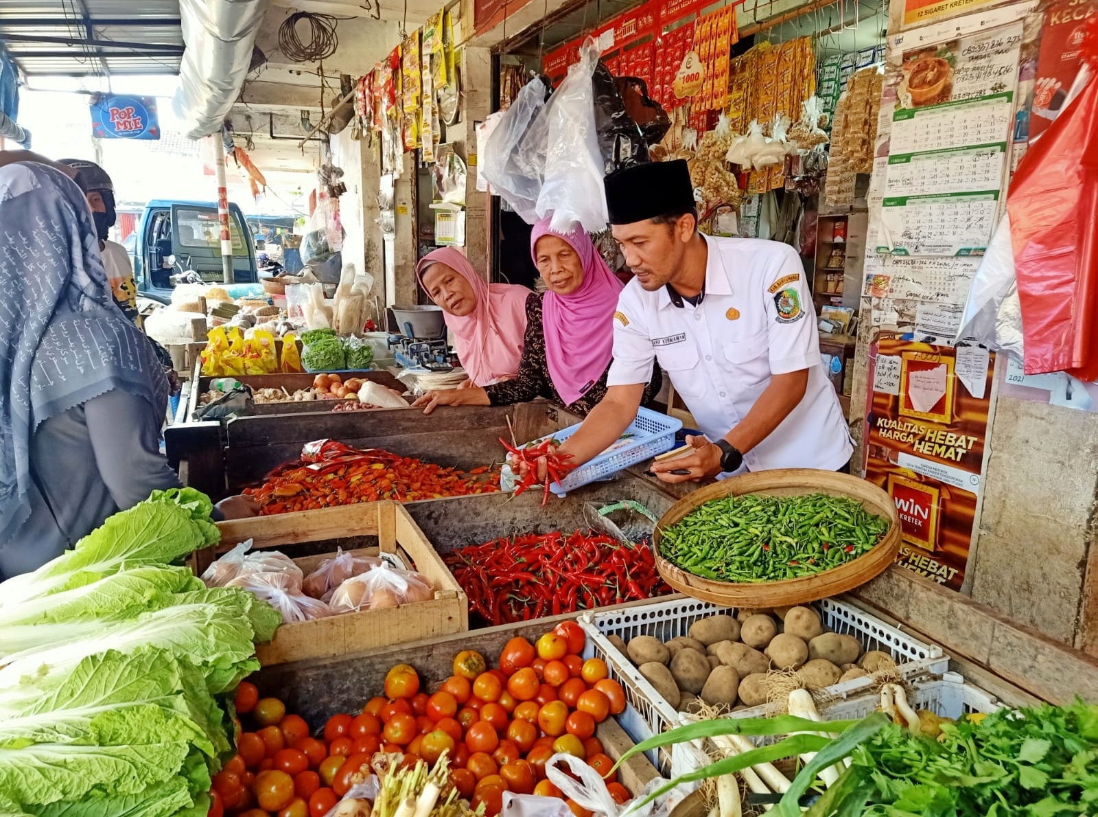 CEK: Petugas Pasar Genteng 1, Desa Genteng Kulon, Kecamatan Genteng Arif Kurniawan mengecek harga jual komoditas di pasar, Rabu (3/9)