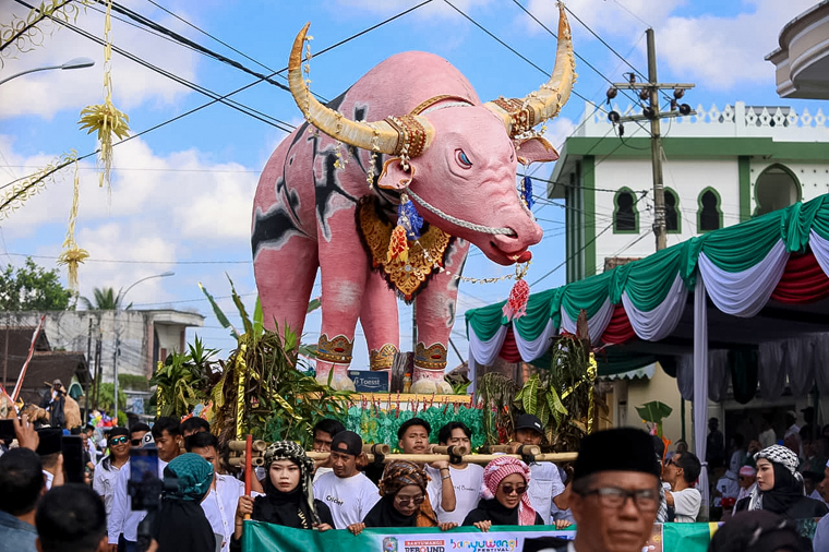 MERIAH: Salah satu peserta pawai Endhog-Endhogan mengusung miniatur kerbau yang sedang membawa bunga telur di Desa Kembiritan, Kecamatan Genteng, Jumat (5/9).