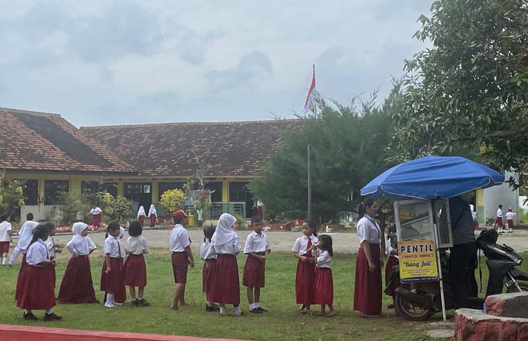 Siswa SDN 2 Kertosari membeli makanan di pedagang kaki lima. Para siswa sekolah tersebut hingga kini belum mendapat program MBG.