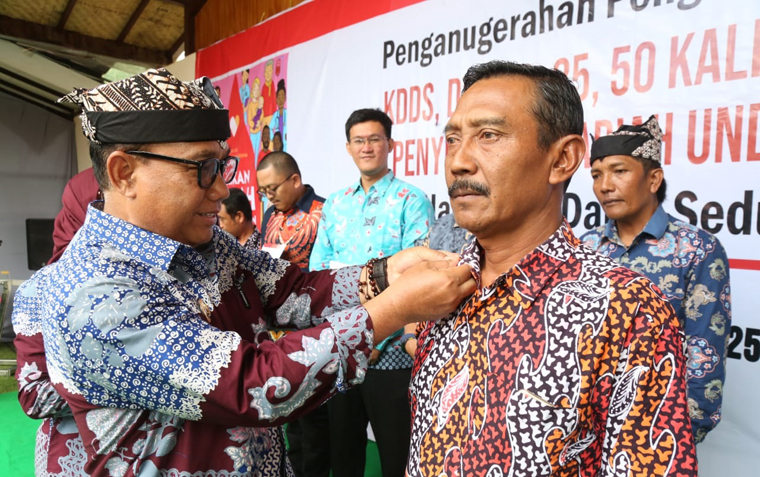 Wabup Mujiono menyematkan lencana penghargaan kepada pendonor darah sukarela di Dakon Resto, Desa Olehsari, Kecamatan Glagah, pada Sabtu (20/9).
