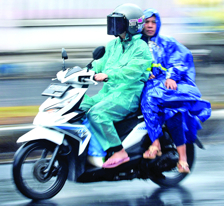 Warga melintas di jalan Yos Sudarso Banyuwangi saat gerimis melanda beberaa hari lalu.