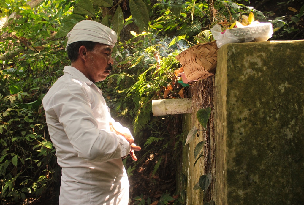 Salah satu sesepuh umat Hindu melakukan ritual sebelum mengambil air suci di Mata Air Tuan .