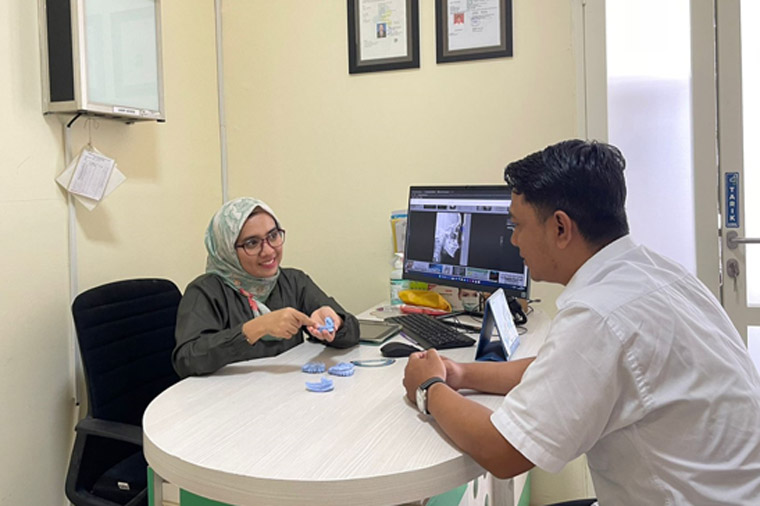 PELAYANAN: drg Iyanda Vemala SpOrt bersama pasien yang konsultasi gigi di RSU Bhakti Husada Krikilan, Kecamatan Glenmore.