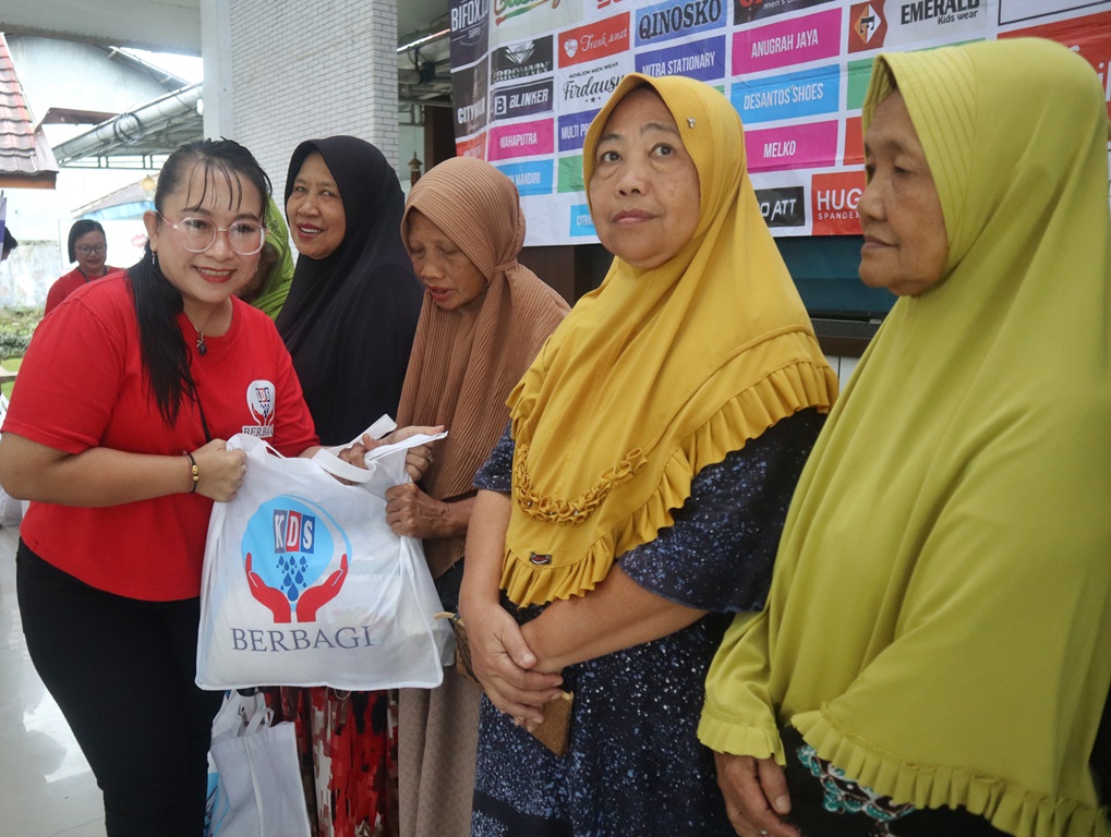 Salah satu pengelola KDS Genteng Mamik Dewi menyerahkan sembako dalam rangka KDS Berbagi di Kantor Kecamatan Genteng pada Rabu (10/9).