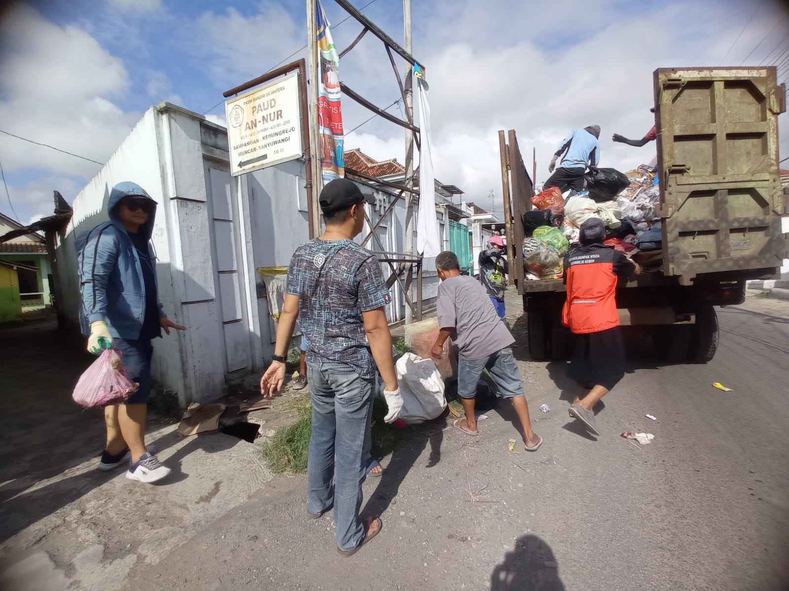 Warga bersama Pemerintah Desa Kedungrejo, Kecamatan Muncar gotong royong membersihkan sampah di pinggir jalan raya Dusun Sampangan, Desa Kedungrejo.