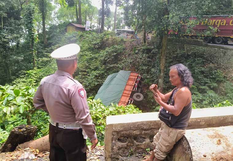 Kondisi truk yang disopiri Ismail, warga Kecamatan Cluring, nyemplung di jurang sedalam 10 meter di Jalur Gumitir, Sabtu (27/9). Anggota Satlantas berbincang dengan sopir truk.