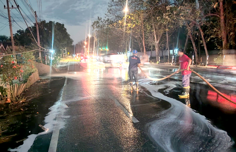 Tim Damkarmat Banyuwangi menyiram solar yang tumpah di badan jalan raya di Desa Bangsring, Kecamatan Wongsorejo pada Jumat malam (26/9).