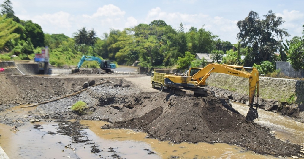 Dua eksavator dikerahkan untuk mengeruk sedimen batu dan pasir di Dam Garit Desa Alasmalang, Kecamatan Singojuruh.