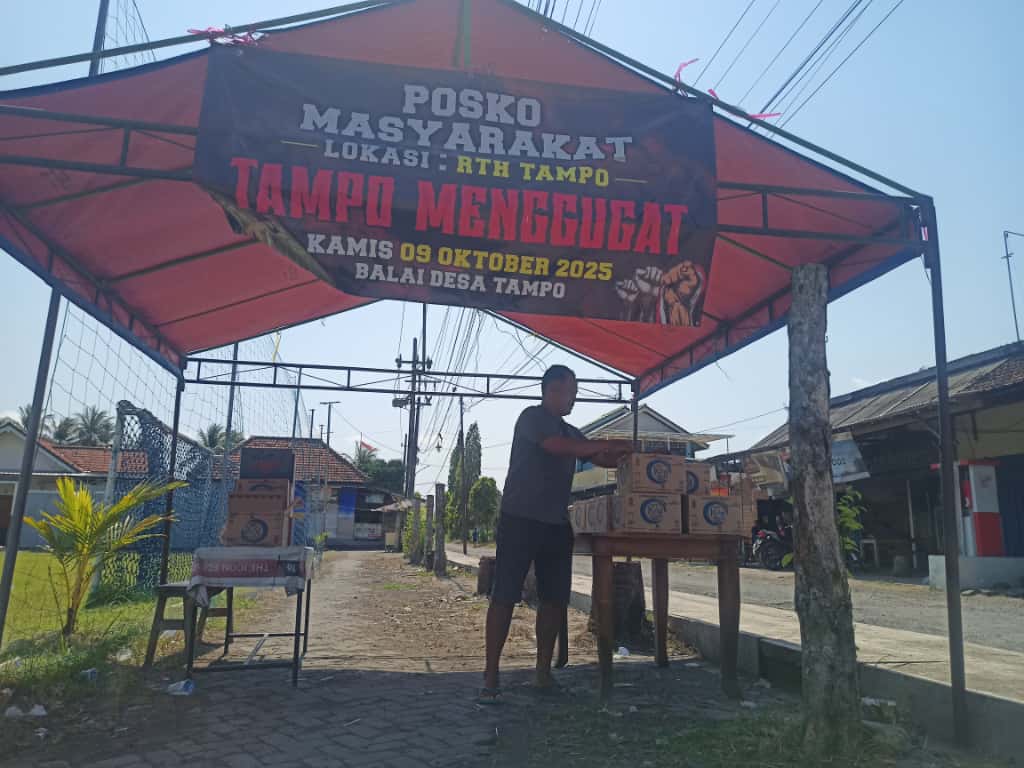 Salah satu warga Desa Tampo, Kecamatan Cluring Supriyadi mengecek logistik yang dikumpulkan masyarakat di RTH lapangan desa.