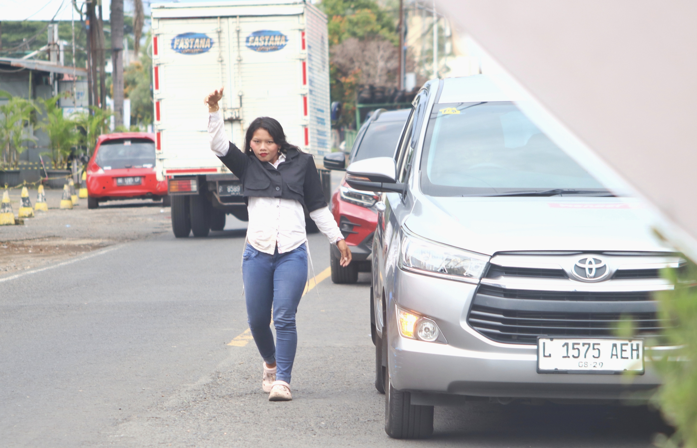 Salah satu pengamen perempuan yang masih usia sekolah menari di traffic light Jalan Gajah Mada, Desa Genteng Kulon.