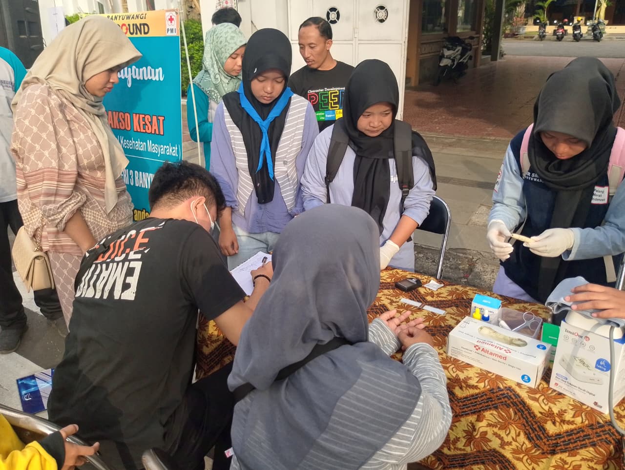 BERDAMPAK: Anggota PMR SMPN 3 Banyuwangi turun langsung ke lapangan untuk memberikan pelayanan kesehatan gratis seperti pemeriksaan tekanan darah, tinggi dan berat badan, dan sebagainya.