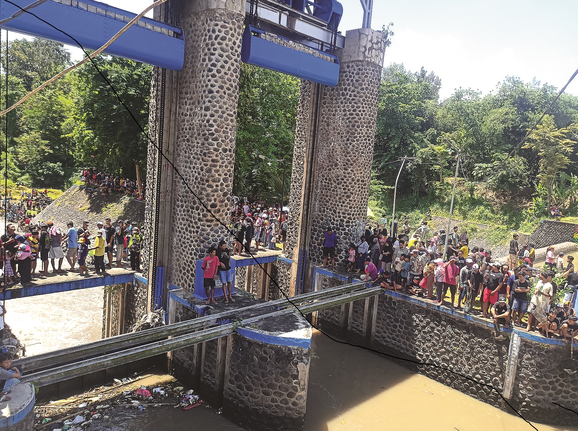 DIKERINGKAN: Ratusan warga tumplek blek di aliran sungai Dam Singir Dusun Mangunrejo, Desa Blambangan, Kecamatan Muncar untuk dan mencari ikan, Minggu (19/10).