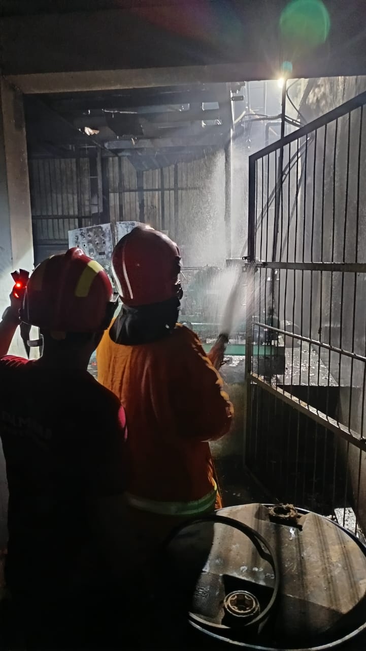 Petugas Damkarmat Sektor Srono memadamkan api di pabrik ikan PT Sumber Yalasamudra di Dusun Sampangan, Desa Kedungrejo, Kecamatan Muncar.