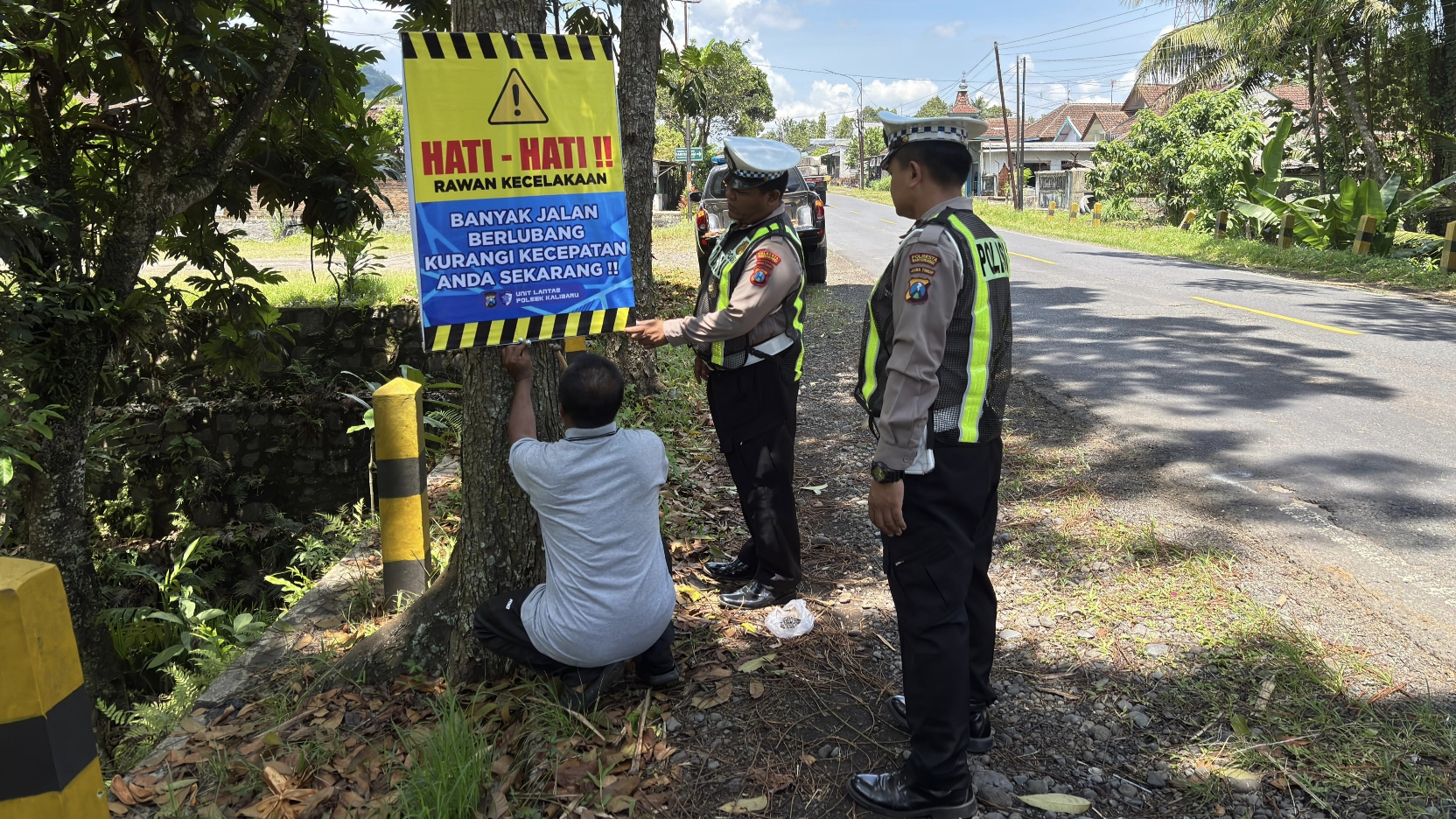 Anggota Unit Lantas Polsek Kalibaru memasang papan peringatan di lokasi rawan kecelakaan yang ada di Kecamatan Kalibaru.