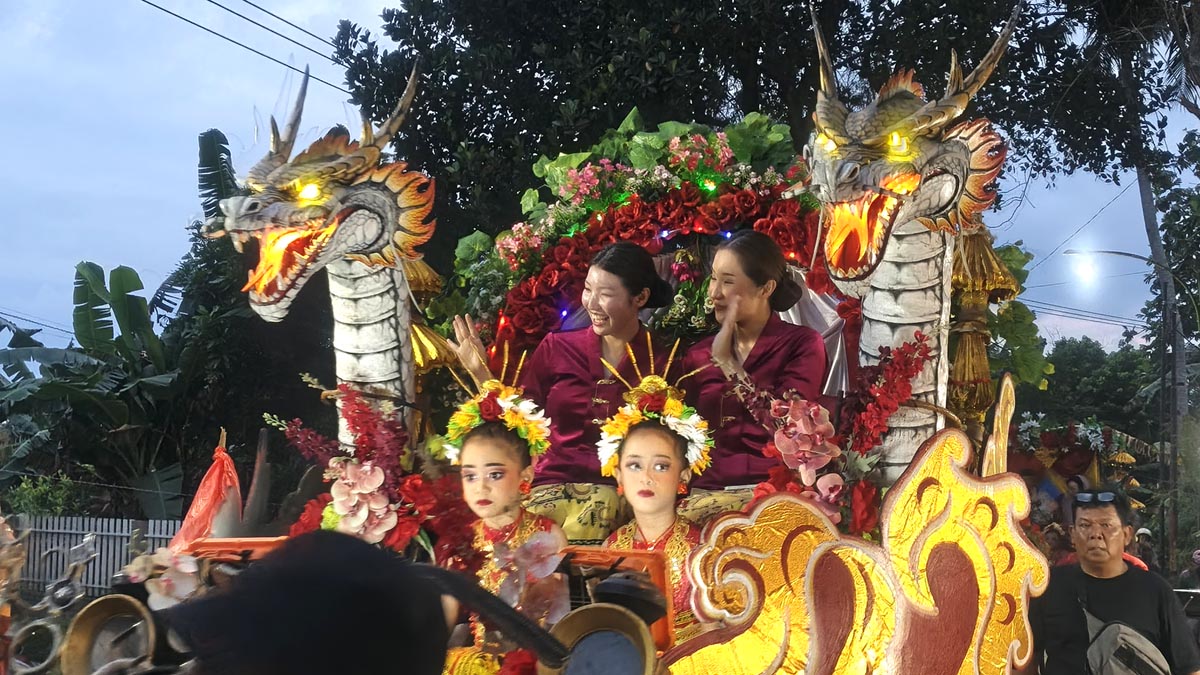 BIKIN HEBOH: Mengenakan baju adat khas Oseng, pasangan Indra Nur Cahya dan Nanako Kobayashi diarak keliling kampung menggunakan kereta hias, Jumat (24/10).