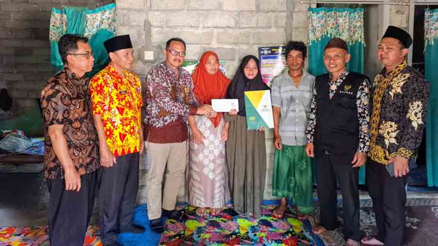 BERBAGI KEBAIKAN: Camat Genteng bersama Tim Baznas menyerahkan bantuan kepada Ana Zahrotun Nafisah didampingi pihak keluarga.