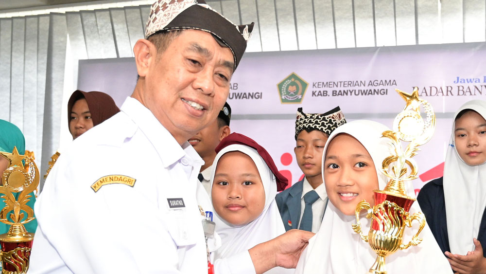 Kepala Dispendik Banyuwangi Suratno memberikan piala kepada pemenang lomba di Seblang Room Grha Pena Banyuwangi.