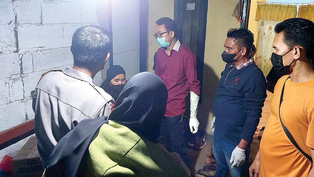 Anggota Polsek Gambiran bersama tim medis Pusekesmas Jajag menemui Wulandari usai memeriksa jenazah Sunarti yang ditemukan tewas di dalam kamarnya, Kamis (30/10).