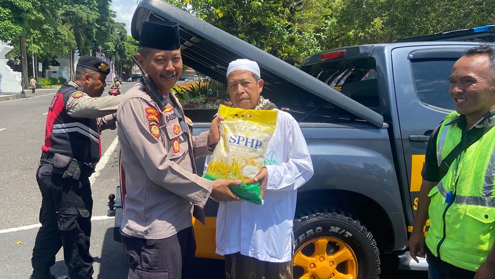 Kasat Samapta Kompol Basori Alwi membagikan beras SPHP kepada masyarakat di sekitar Taman Sritanjung, Jumat (31/10).