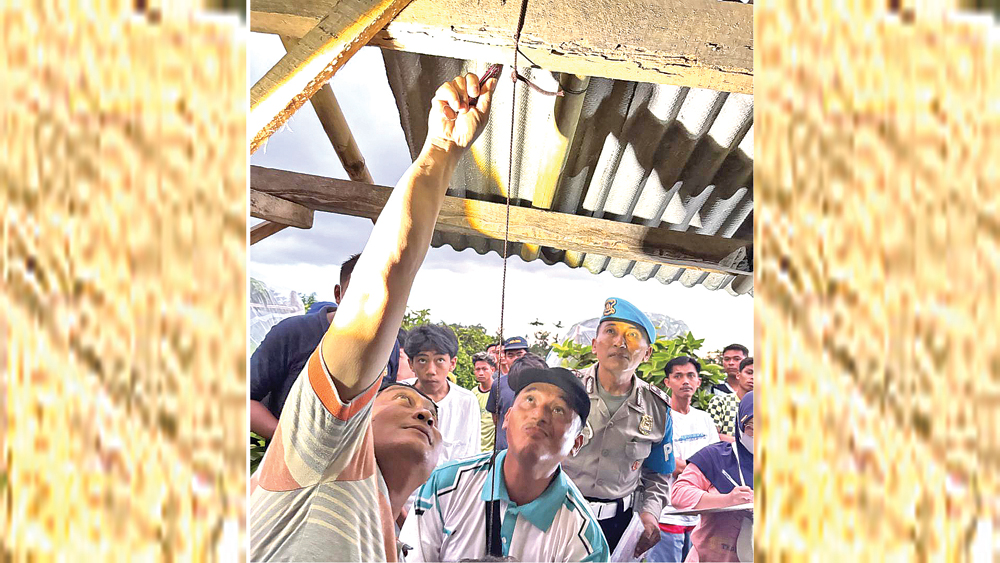 Anggota Polsek Bangorejo disaksikan warga melepas tali yang diduga digunakan korban untuk mengakhiri hidup pada Sabtu sore (1/11).