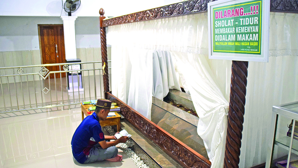 Salah satu pengunjung sedang berdoa di makam Mbah Wali Hasan Dusun Sumberkepoh, Desa Kedungwungu, Kecamatan Tegaldlimo, Senin (3/11).
