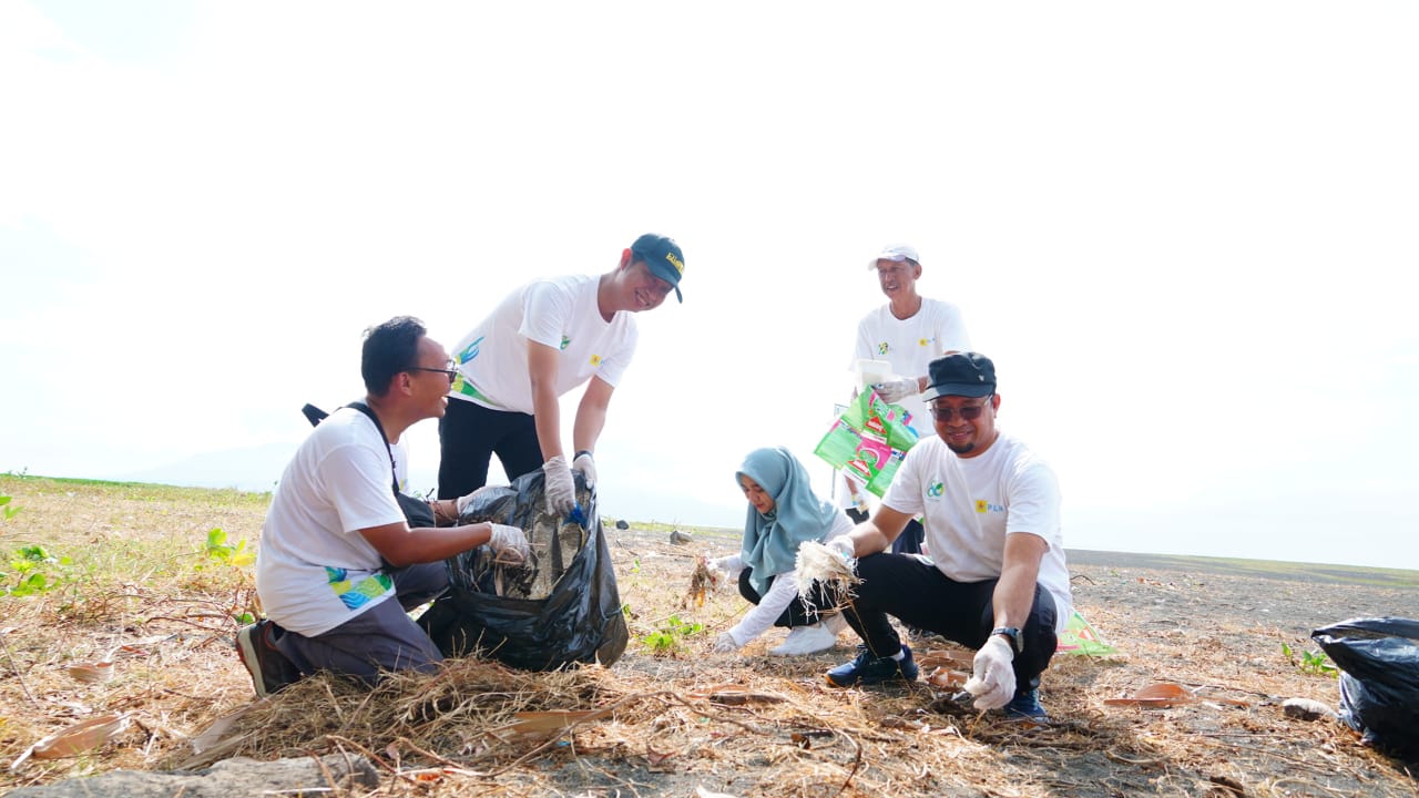PEDULI LINGKUNGAN: Jajaran PLN UP3 Banyuwangi bersih-bersih sampah di Pantai Marina Boom Banyuwangi.