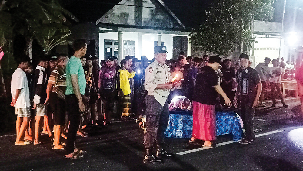 Kepala SPKT 2 Polsek Bangorejo Aiptu Suyanto mengatur arus lalu lintas di jalan raya Sambimulyo, Bangorejo, usai terjadi kecelakaan pada Kamis malam (6/11).