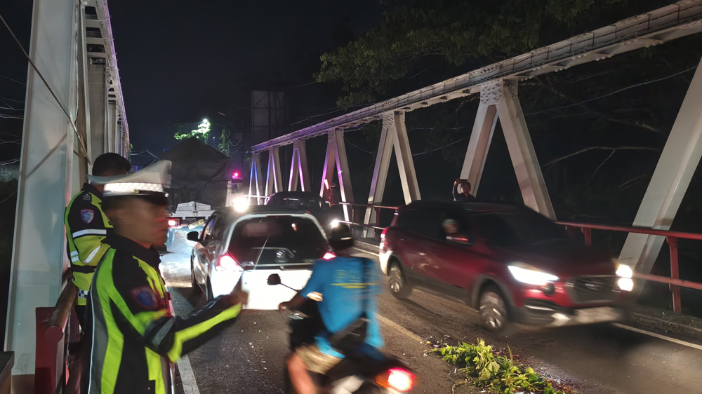 ATUR LALIN: Petugas Unit Lantas Polsek Rogojampi melakukan olah TKP tabrak lari di Sasak Tambong, Jalan Raya Kabat, Jumat (7/11) malam.