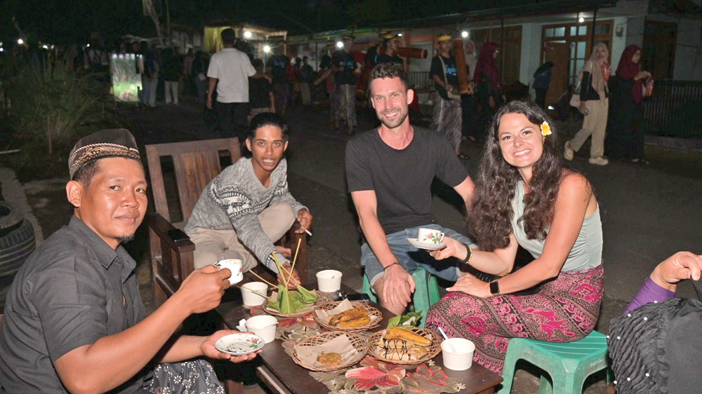 KAGUM KERAMAHAN WARGA: Sepasang wisatawan asal Republik Ceko menikmati kopi gratis yang disuguhkan warga Desa Kemiren, Kecamatan Glagah.