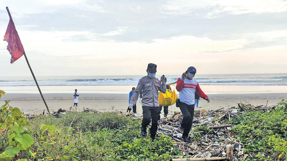 MEMIKUL: Anggota Polsek Tegaldlimo bersama petugas TNAP mengevakuasi jenazah yang ditemukan di Pantai Rowobendo Alas Purwo, Sabtu (8/11).
