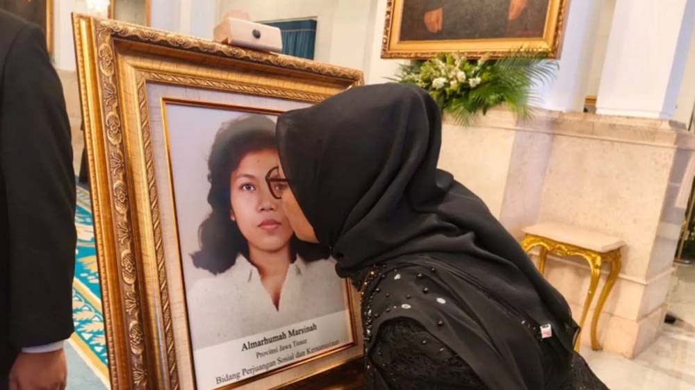 Adik Marsinah, Wijiati (54), mencium foto sang kakak seusai agenda Penganugerahan Pahlawan Nasional kepada Marsinah di Istana Negara, Jakarta, Senin (10/11/2025).