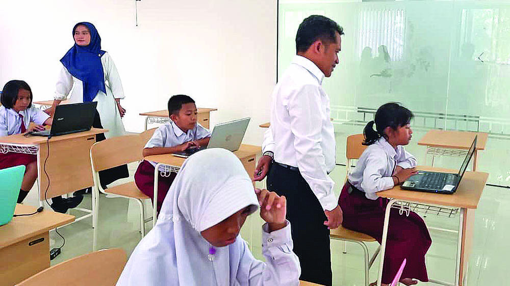 FASILITAS GRATIS: Sejumlah pelajar menjajal laptop yang akan dibagikan secara cuma-cuma kepada seluruh siswa SRT 46 Muncar, Selasa (11/11).