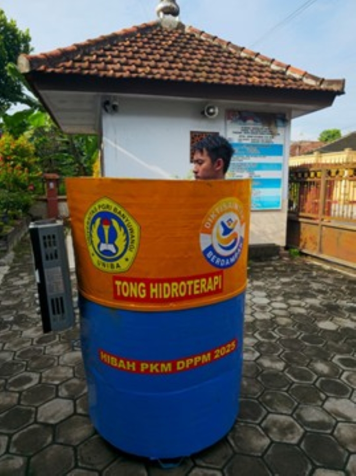 Tim PKM mendemonstrasikan penggunaan tong hidroterapi dengan seorang penari junior setelah sesi latihan.