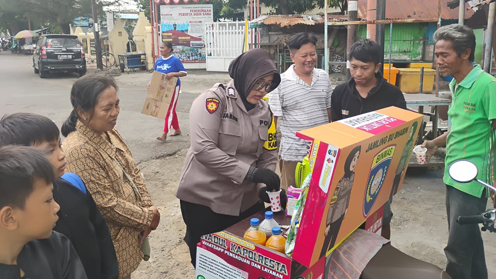 Brigadir Barani melayani masyarakat Kampung Melayu yang ingin merasakan jamu tradisional.