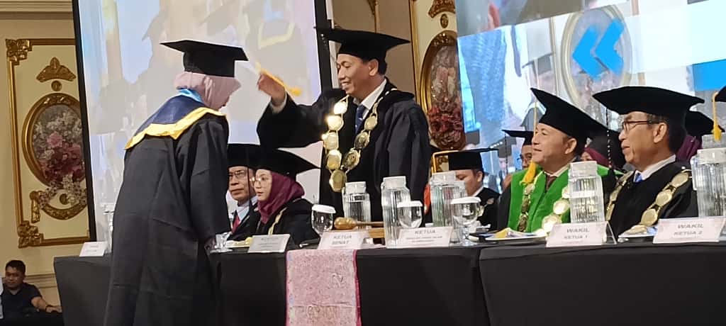 SIMBOLIS: Rektor Universitas Bakti Indonesia Dr. Haya, SHI., M.Pd.I saat memindahkan tali tiga wisudawati UBI, di Aston Hotel, Sabtu (15/11).