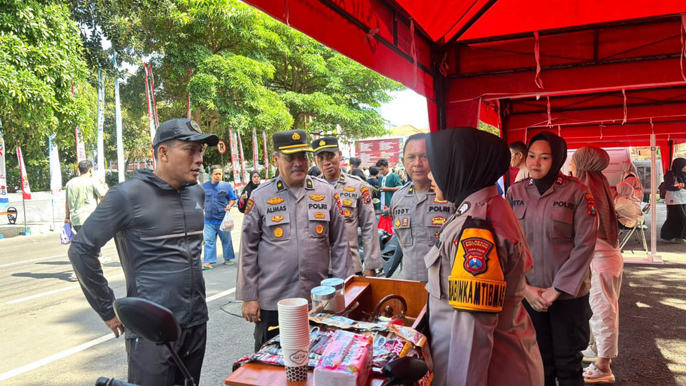SOSIALISASI: Anggota SDM Polresta Banyuwangi membagikan brousur kepada warga pada acara CFD di Jalan Ahmad Yani Banyuwangi, Minggu (16/11).