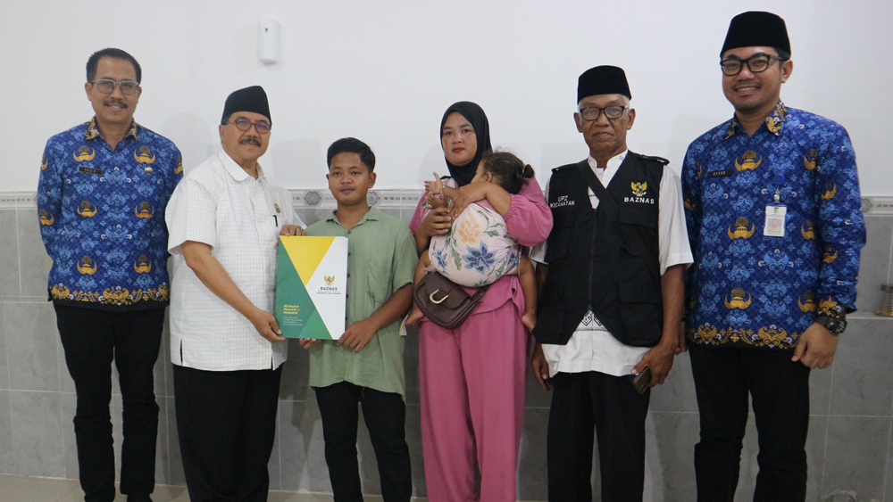 PEDULI SESAMA: Wakil Ketua Baznas Herman Suyitno menyerahkan bantuan kepada DN disaksikan keluarga, pihak Dinkes dan perwakilan RSUD Blambangan.