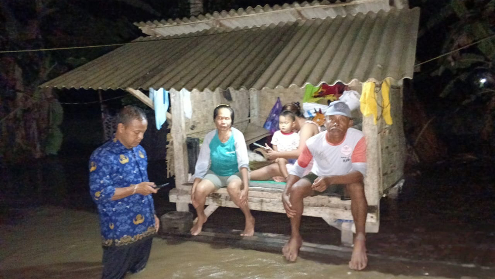 BERTEDUH DI GARDU: Nur Yasin beserta keluarganya memaksa bertahan di gardu miliknya saat banjir melanda Lingkungan Wonosari, Kelurahan Sobo, Senin malam (17/11).
