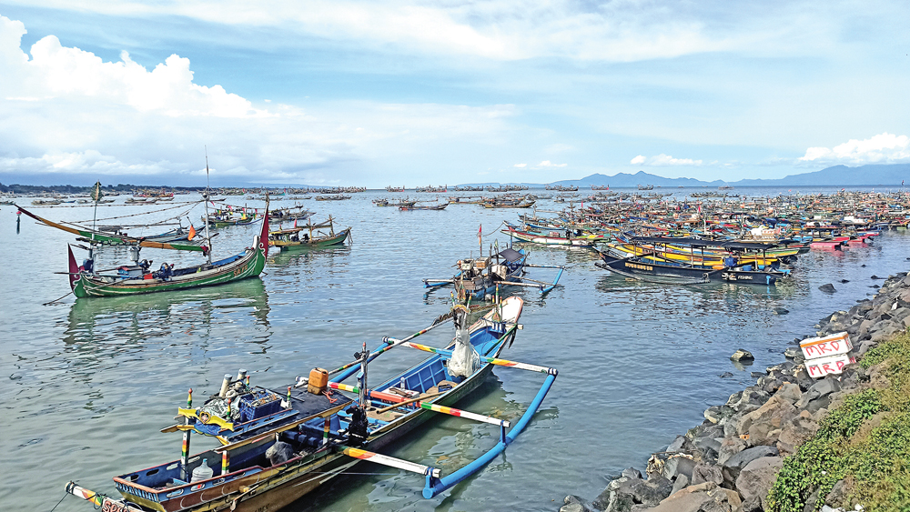 BERKUMPUL: Ratusan perahu sandar di kawasan Pelabugan Muncar, Selasa (18/11).