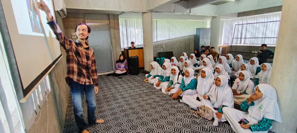 Siswa MI Darun Najah 2 Banyuwangi mendengarkan materi produksi berita dan koran di Ruang Seblang Grha Pena Jawa Pos Radar Banyuwangi, Rabu (19/11/2025).