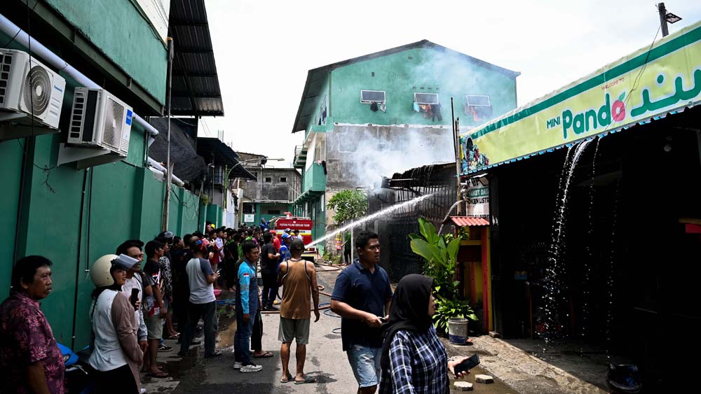 Petugas damkarmat menyemprotkan air ke titik api yang membakar gudang perabotan rumah tangga di Jalan Ikan Windu, Kelurahan Tukangkayu, Rabu (19/11).