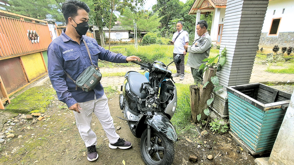 RUSAK: Warga menepikan sepeda motor yang terlibat kecelakaan lalu lintas di Desa Kalibaru Wetan, Kecamatan Kalibaru, Rabu (19/11).