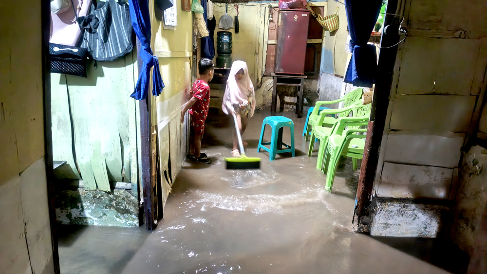 LANGGANAN BANJIR: Warga yang tinggal di Lingkungan Lebak, Kelurahan Tukangkayu, Banyuwangi, membersihkan lantai rumahnya dari genangan air, Kamis (20/11).