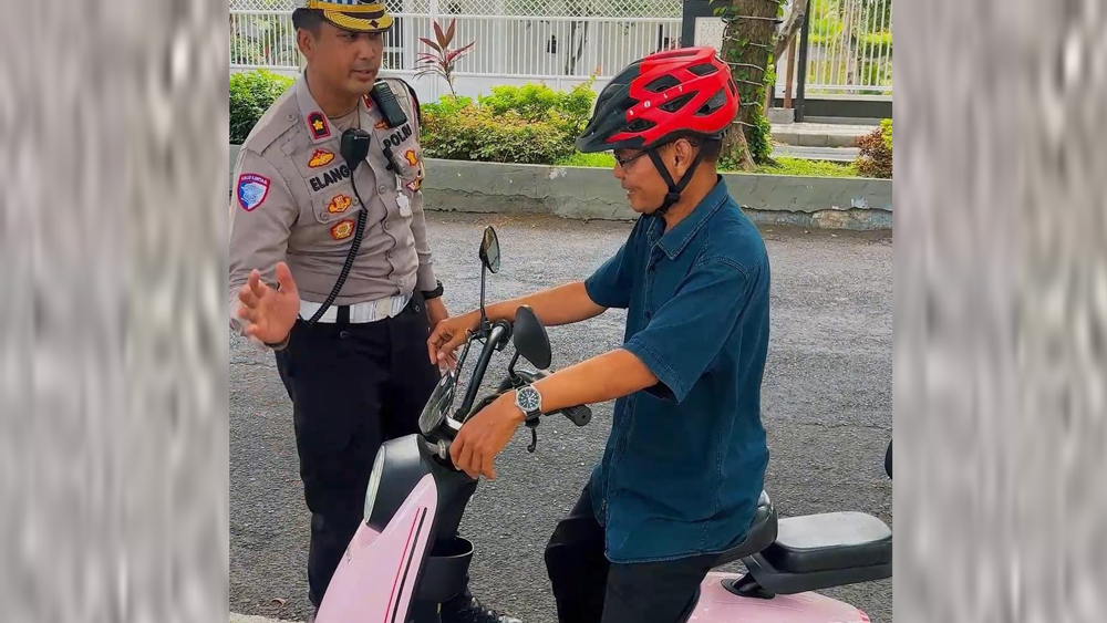DITEGUR: Kompol Elang Prasetyo menghentikan pengendara sepeda listrik saat melintas di traffic light depan kantor DPRD Banyuwangi, Kamis (20/11).