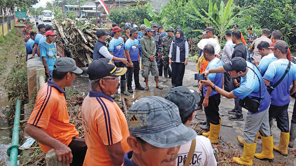 TINJAU LAPANGAN: Bupati Ipuk Fiestiandani saat meninjau sungai yang meluap akibat hujan lebat di Desa Sumberagung, Kecamatan Pesanggaran, Minggu (23/11).